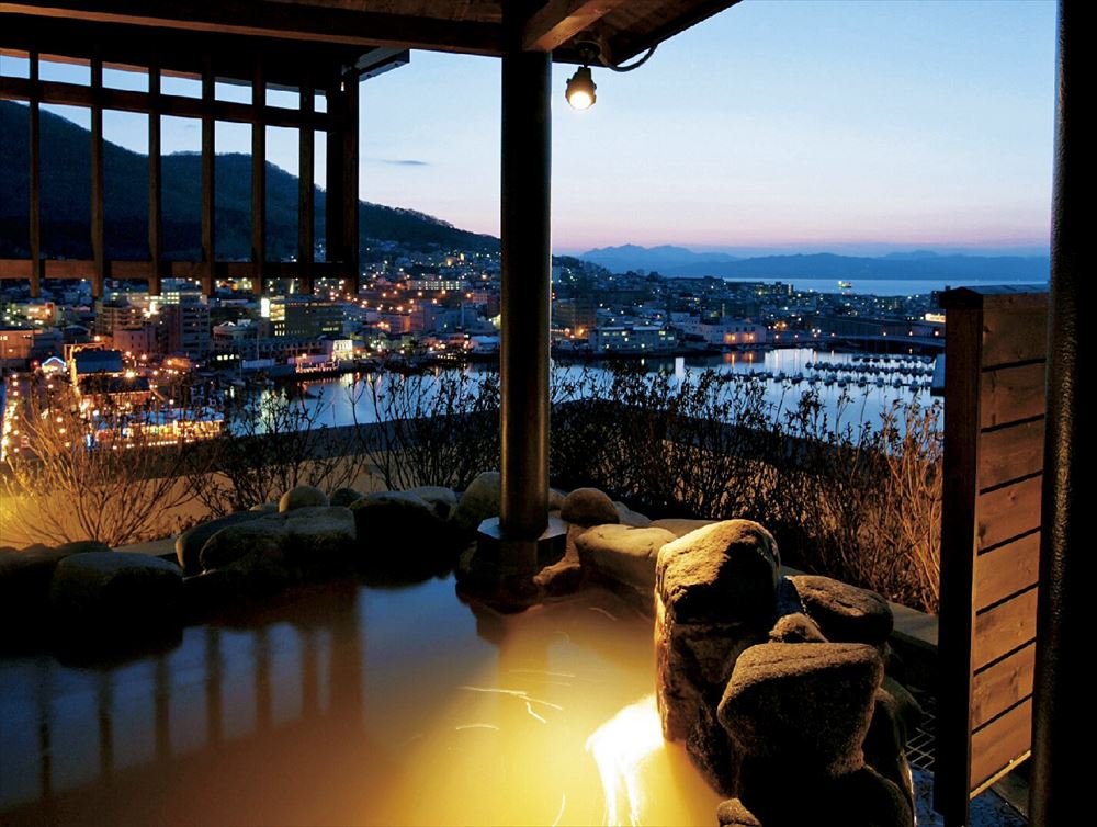 LA VISTA Hakodate Bay_Open-air bath in the large common bathing area. Savor a romantic moment gazing out over the city lights at night.