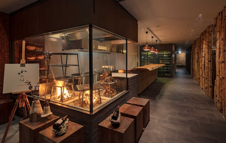 FUFU KAWAGUCHIKO JAPAN_Restaurant Yamanoha. Locally grown seasonal ingredients are grilled over wood-burning flames and lava stones. Theater-style seating ensures that everyone can enjoy dining with a view in this seamless space.