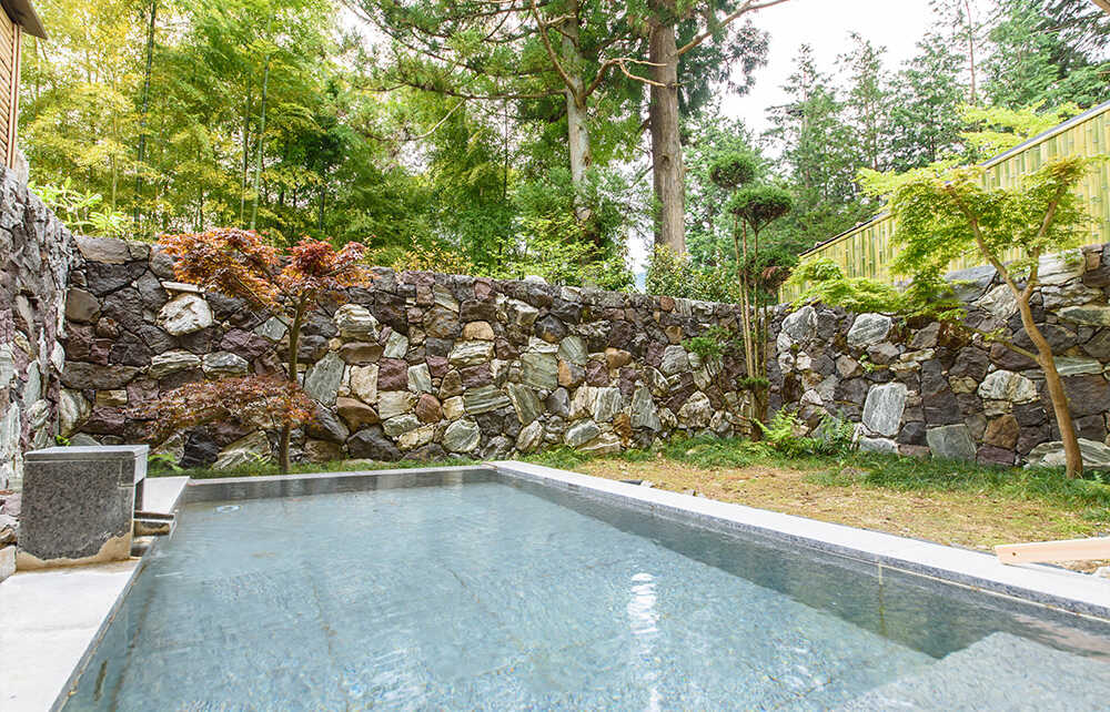 Hakone・Suishoen_Open-air bath in the large common bathing area. Gaze at the garden and feel the beauty of the seasons while relaxing in the bath. The common bathing area also offers the pleasures of a dry sauna.