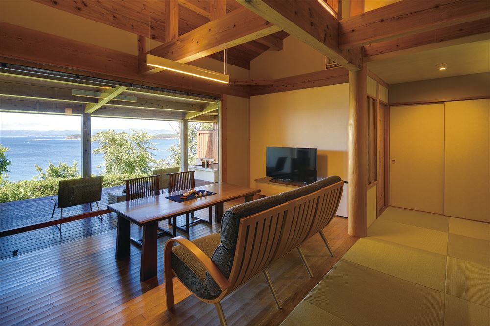 Hamachidori no Yu Kaisyu_Living room and terrace chairs facing the large window of the villa.