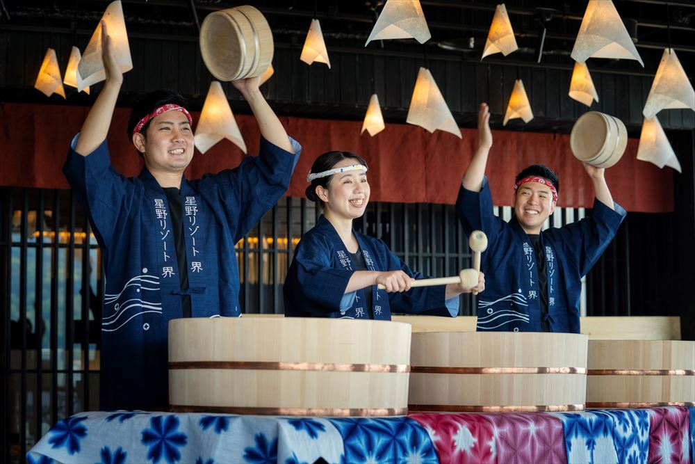 星野集團 界 別府_館內人員身著「法披」(傳統日式外套)敲擊著化身為樂器、大大小小的溫泉木桶，獨特的「瓶罐樂隊演奏會」帶您體驗昔日別府街鎮熱鬧多彩的夜生活氣氛。