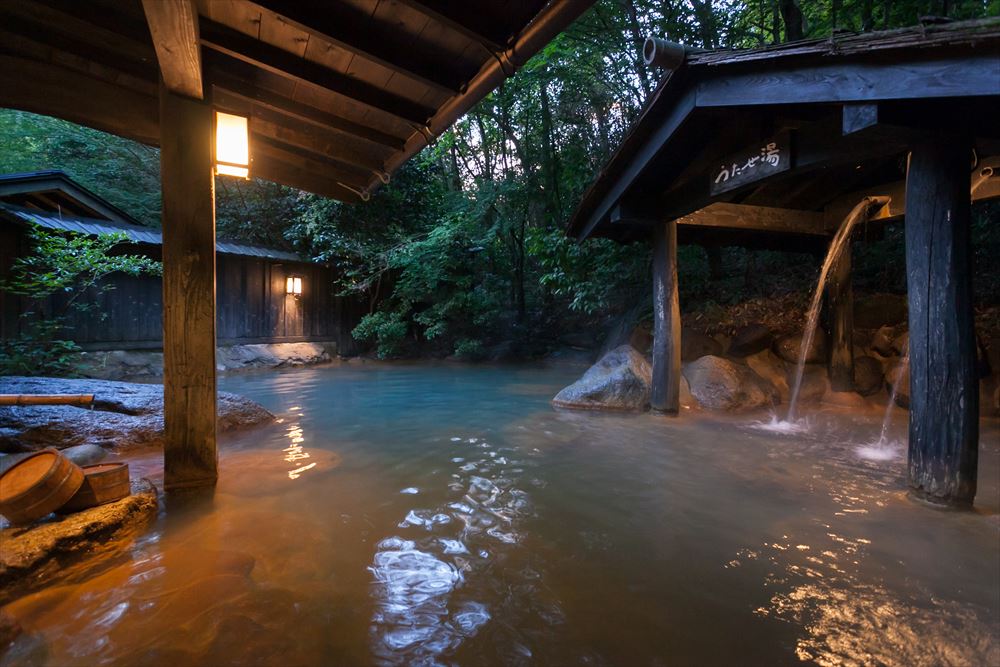 旅館 山河。混浴露天浴場，在動感的大自然環繞下，泛著藍光的透明泉水是其特徵。也可體驗「定點流溫泉」。