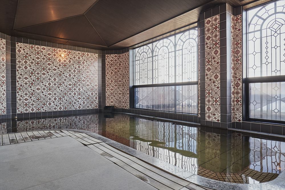 上諏訪温泉「しんゆ」。畳敷きの大浴場。壁にタイルを敷き詰めて、美しくも個性的な温泉を演出。