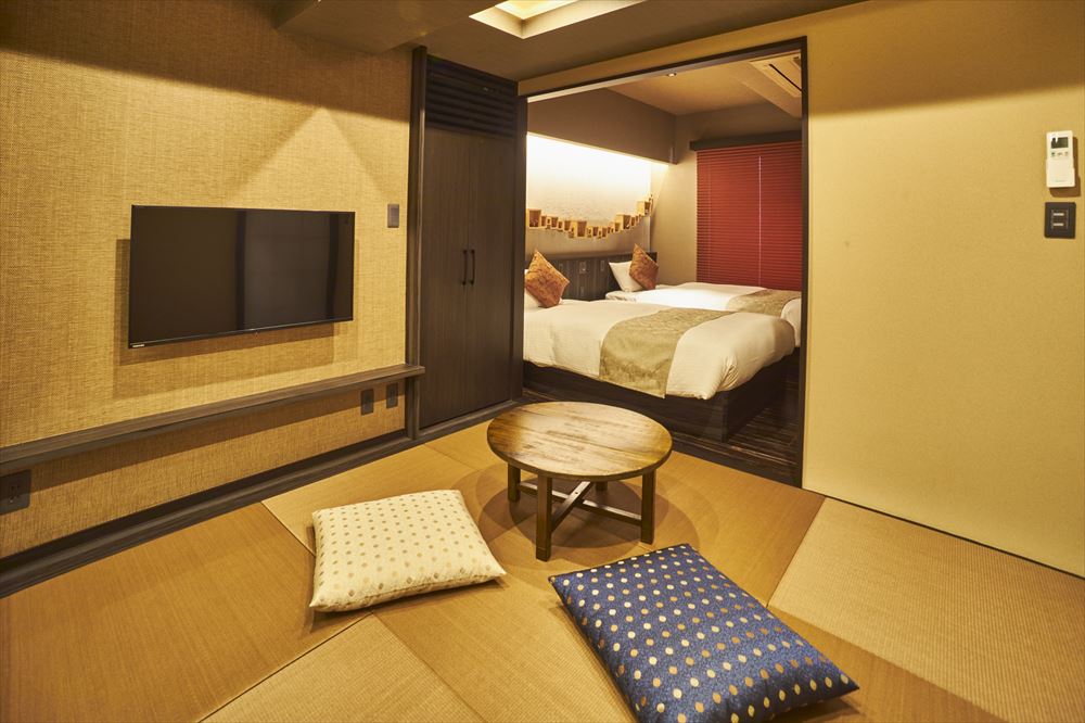 SAKE Bar Hotel 浅草のKomodaru(Superior twin)。畳のリビングには小ぶりなちゃぶ台と座布団。フローリングのお部屋にはツインベッド。